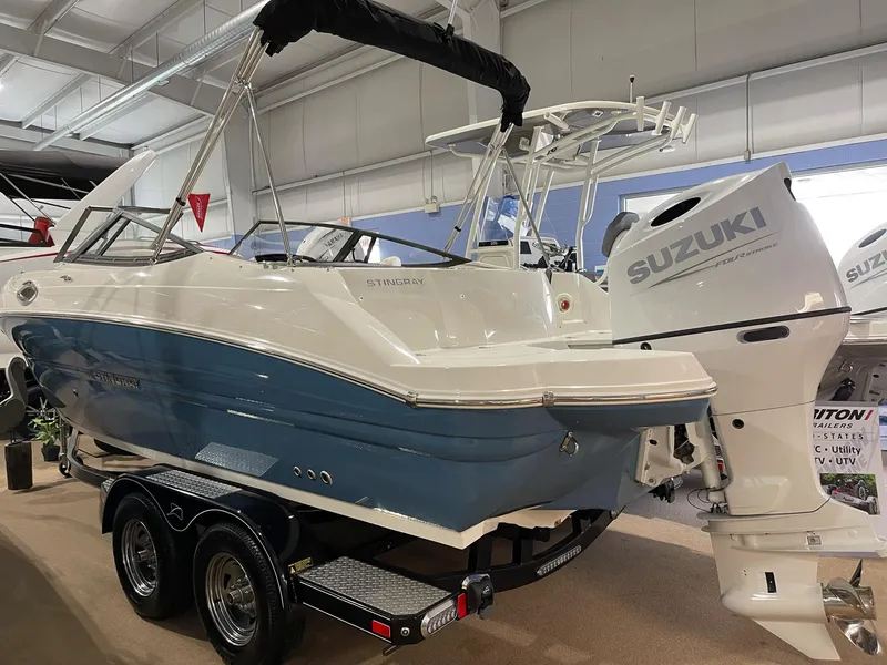 Slide: The Image of 2023 Stingray 211DC boat with Suzuki outboard motor on display in showroom. - 6