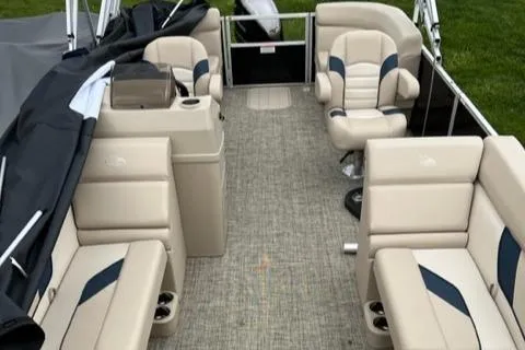 Slide: The Image of 2023 SunCatcher Select 20RC pontoon boat interior with beige seating and gray flooring. - 2