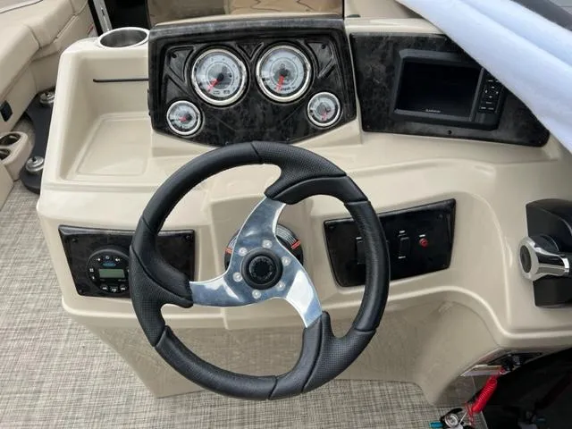 Slide: The Image of 2023 SunCatcher Select 20RC boat dashboard with steering wheel and gauges. - 4