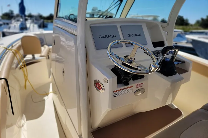 Slide: The Image of 2020 Scout 255 LXF boat helm with dual Garmin displays and steering wheel. - 18