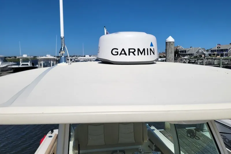 Slide: The Image of 2020 Scout 255 LXF boat with Garmin radar on roof, docked at marina. - 16
