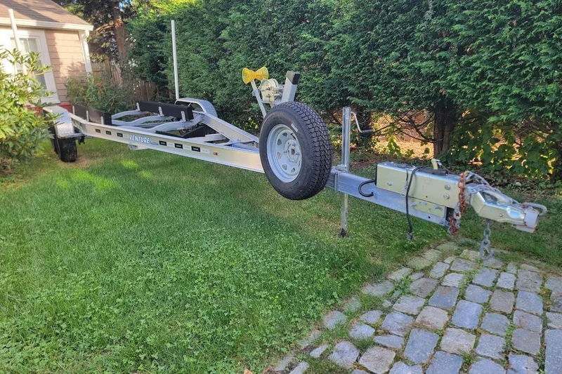Slide: The Image of Trailer for 2020 Scout 255 LXF boat on grass near hedges. - 36