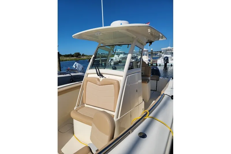 Slide: The Image of 2020 Scout 255 LXF boat with beige seating, docked at a marina. - 6