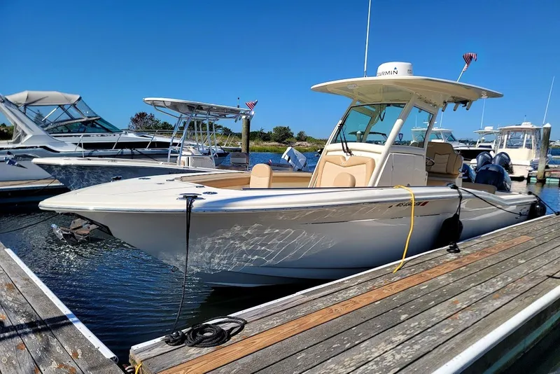 Slide: The Image of 2020 Scout 255 LXF boat docked at marina under clear blue sky. - 4