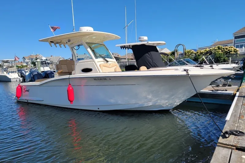 The Image of 2020 Scout 255 LXF boat docked in a marina under clear blue skies. - 0