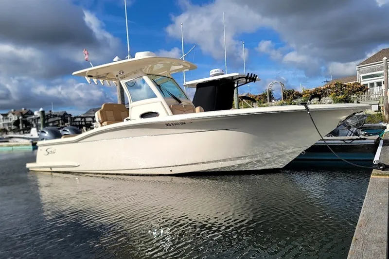 Slide: The Image of 2020 Scout 255 LXF boat docked at marina under cloudy sky. - 6