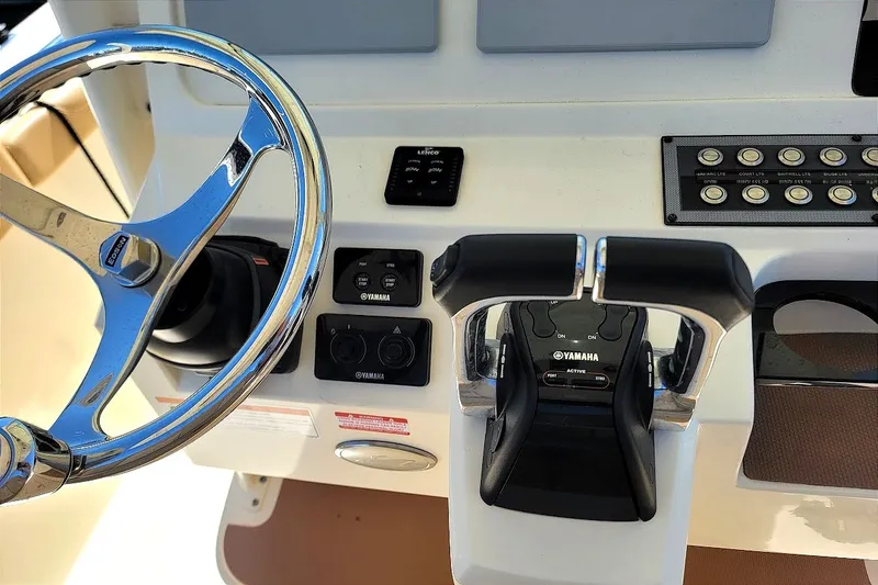 Slide: The Image of Steering wheel and controls of a 2020 Scout 255 LXF boat. - 19