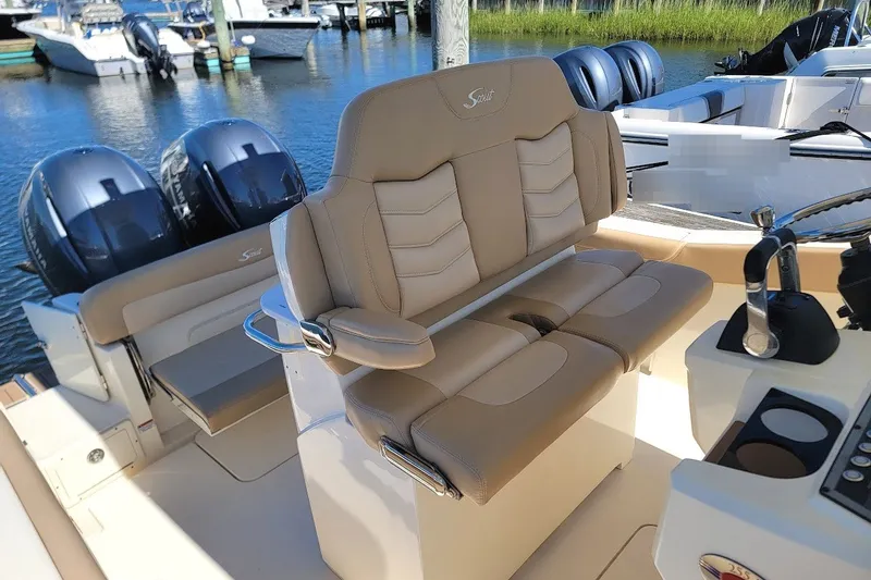 Slide: The Image of 2020 Scout 255 LXF boat interior with beige seating and dual engines. - 17