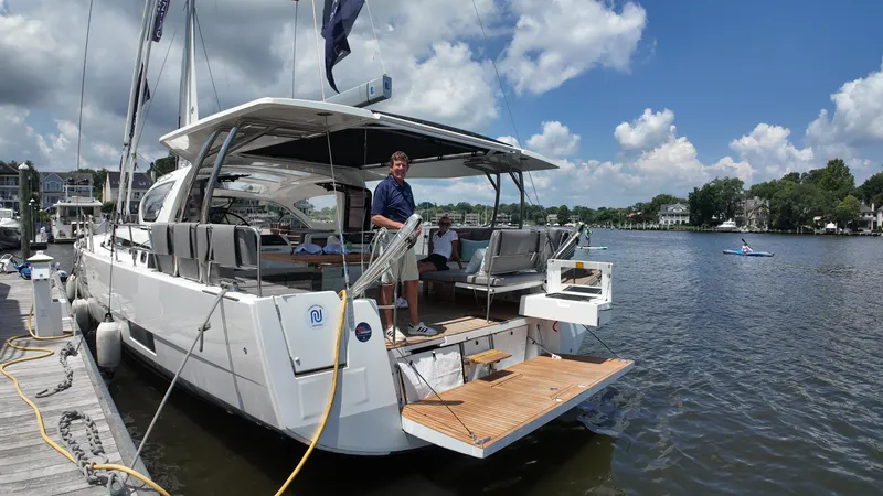 Slide: The Image of 2024 Jeanneau 55 yacht docked, featuring spacious deck and modern design. - 2