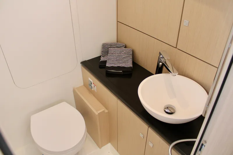 Slide: The Image of Modern bathroom in 2024 Jeanneau 55 yacht with sink, toilet, and striped towels. - 25