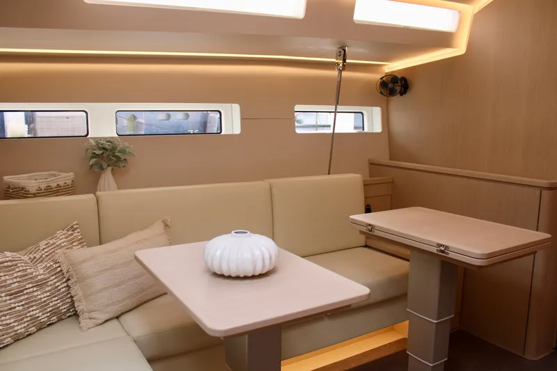 Slide: The Image of Modern interior of 2024 Jeanneau 55 yacht with beige seating and dual tables. - 26