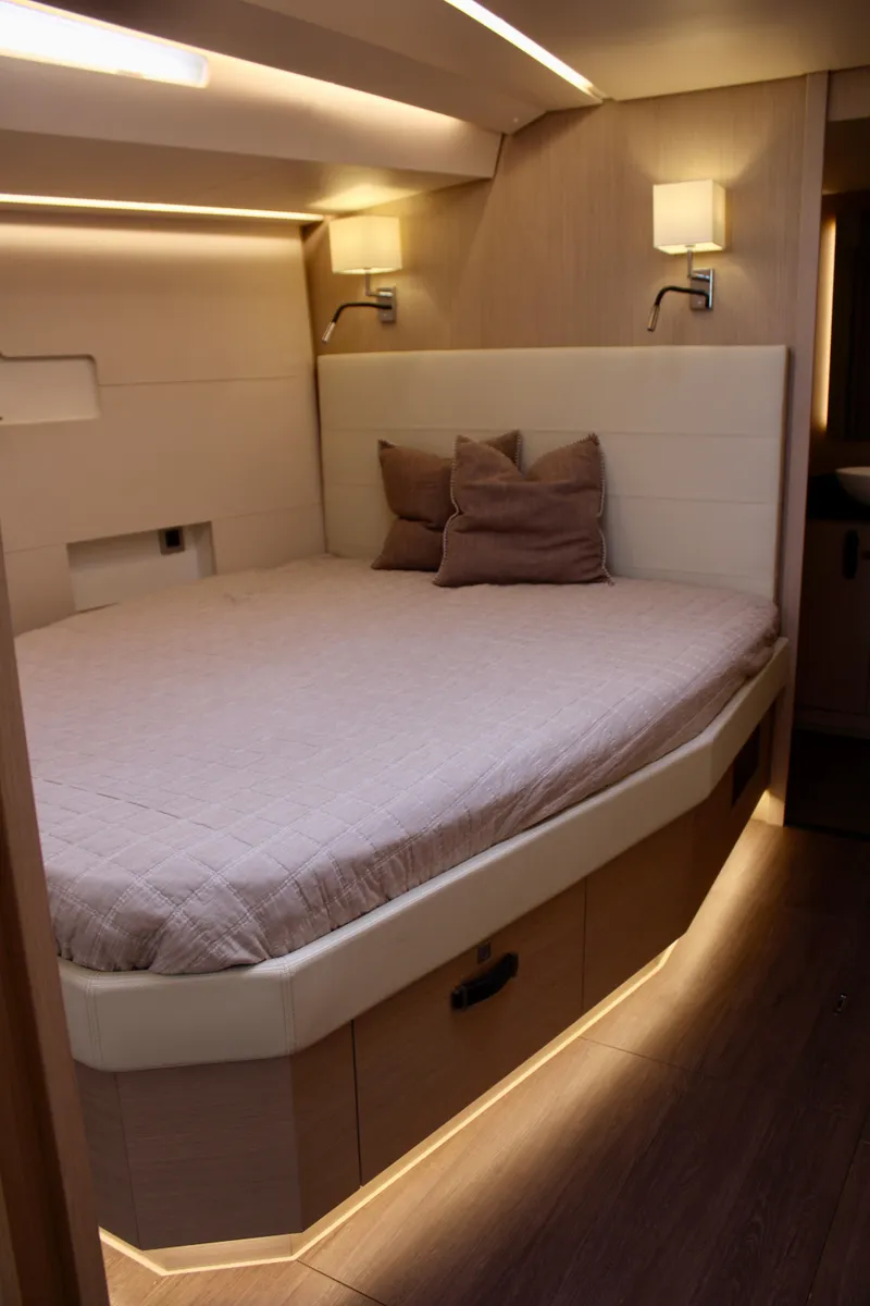 Slide: The Image of 2024 Jeanneau 55 yacht interior cabin with modern lighting and cozy bed. - 28