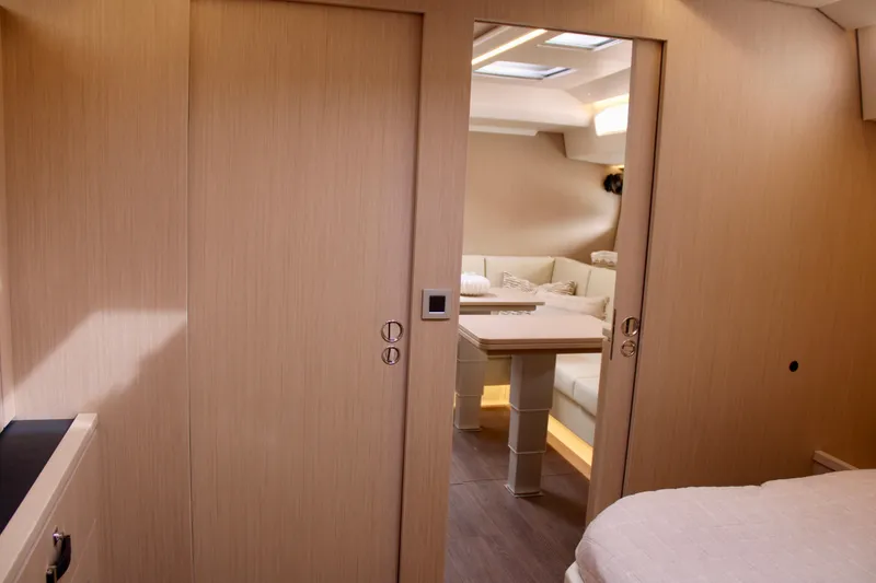 Slide: The Image of Interior of 2024 Jeanneau 55 yacht with modern wood finish and cozy seating area. - 29