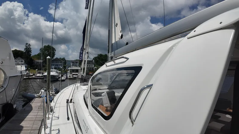 Slide: The Image of 2024 Jeanneau 55 sailboat docked at marina under cloudy sky. - 3