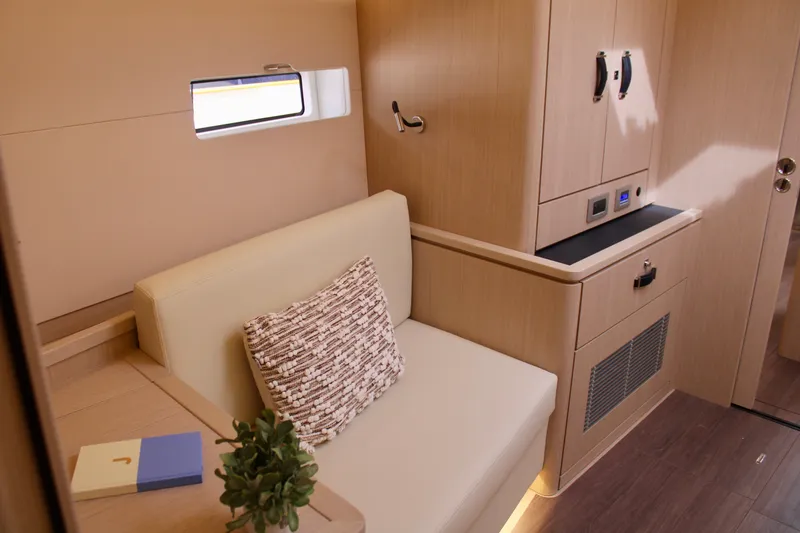 Slide: The Image of Modern interior of 2024 Jeanneau 55 yacht with beige seating and wooden cabinetry. - 31