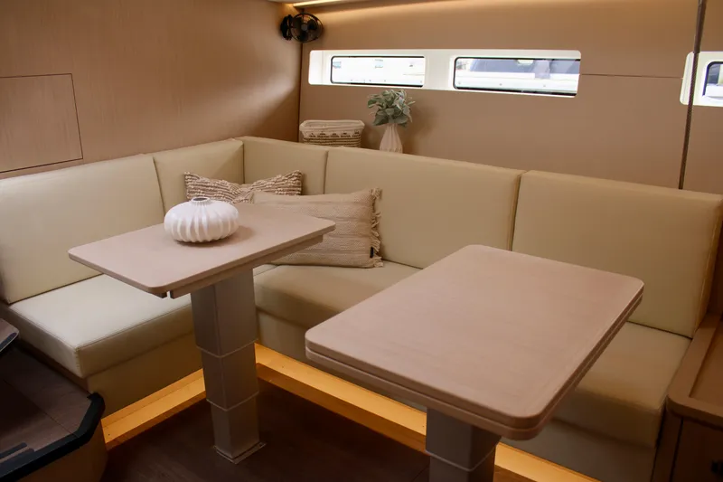 Slide: The Image of Luxurious interior of 2024 Jeanneau 55 yacht with beige seating and dual tables. - 40
