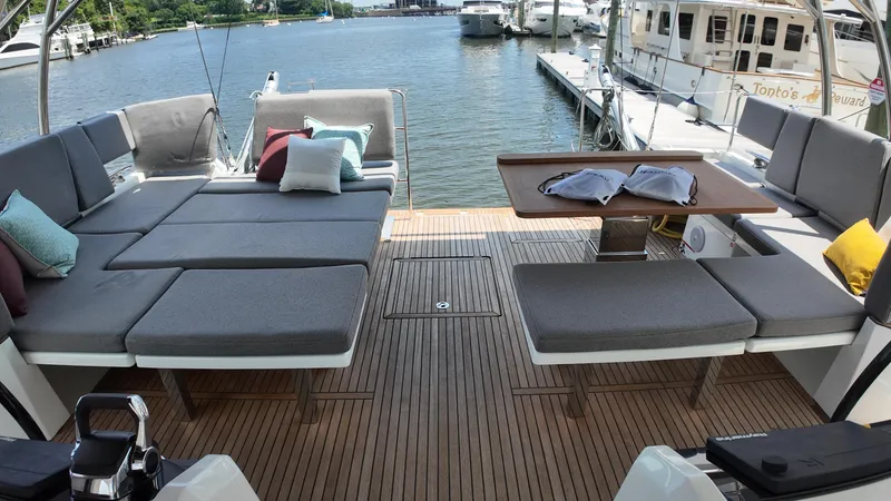 Slide: The Image of Luxurious 2024 Jeanneau 55 yacht deck with comfortable seating and elegant wooden flooring. - 8