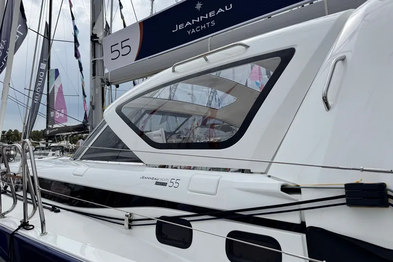 Slide: The Image of 2024 Jeanneau 55 yacht at a marina, showcasing sleek design and modern features. - 2