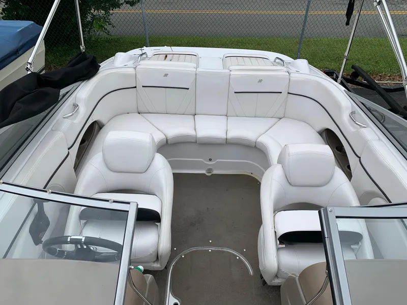 Slide: The Image of 2010 Four Winns H220 boat interior with white leather seating and open bow layout. - 3