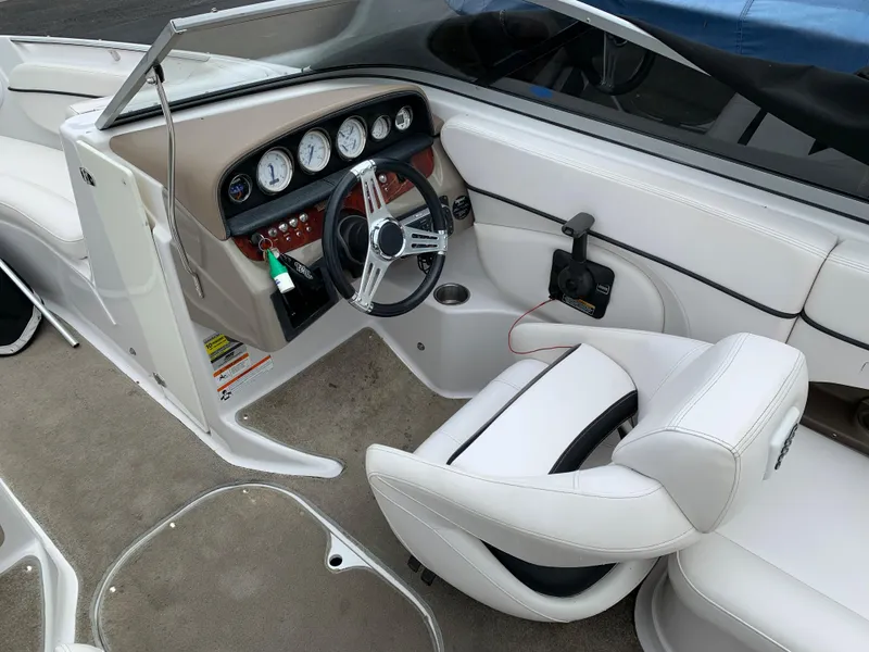 Slide: The Image of 2010 Four Winns H220 boat interior with white leather seats and dashboard. - 4