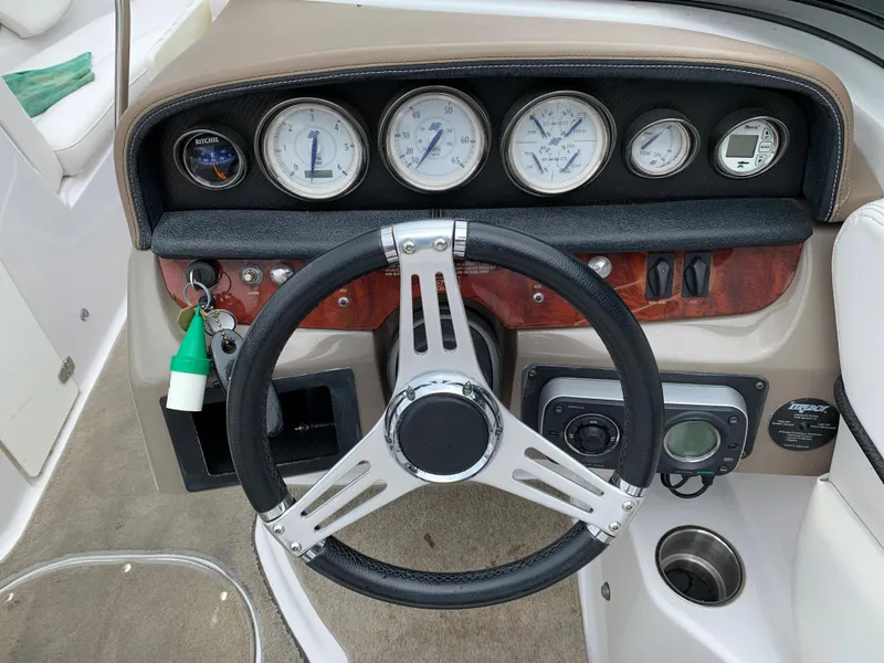 Slide: The Image of 2010 Four Winns H220 boat dashboard with steering wheel and gauges. - 5
