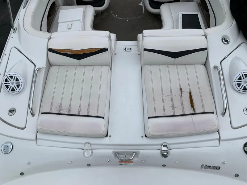 Slide: The Image of 2010 Four Winns H220 boat with worn white seats and visible damage. - 7