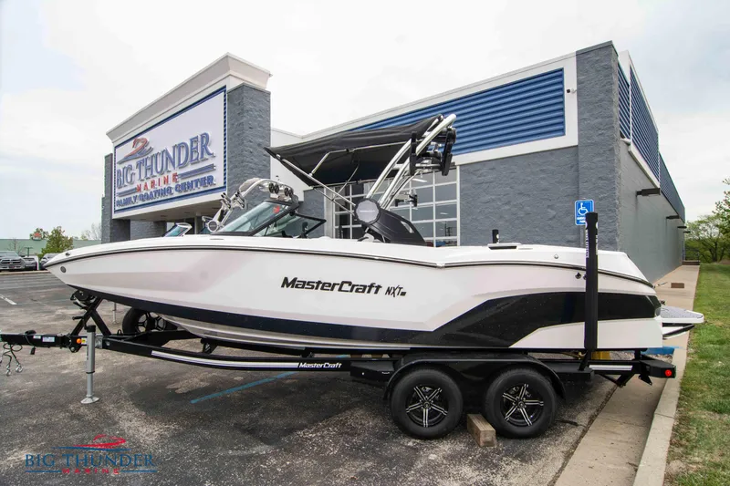 Slide: The Image of 2023 MasterCraft NXT22 boat on trailer outside Big Thunder Marine Center. - 1
