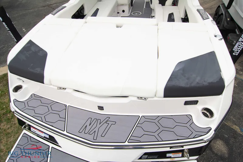 Slide: The Image of 2023 MasterCraft NXT22 boat rear view with white and gray seating. - 10