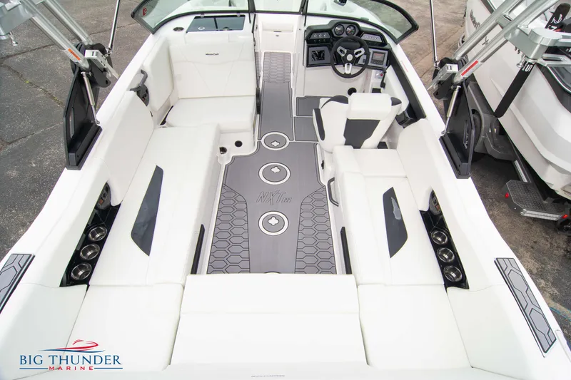 Slide: The Image of 2023 MasterCraft NXT22 boat interior with white seating and modern dashboard. - 13