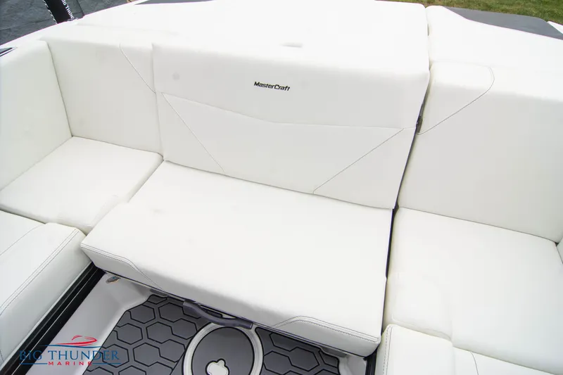 Slide: The Image of 2023 MasterCraft NXT22 boat interior with white cushioned seating and hexagonal floor design. - 19