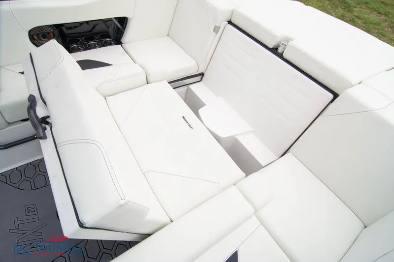 Slide: The Image of 2023 MasterCraft NXT22 boat interior with white seating and storage compartments. - 20