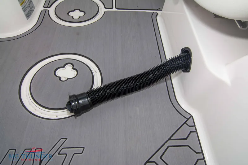 Slide: The Image of 2023 MasterCraft NXT22 boat interior with flexible hose on gray flooring. - 23