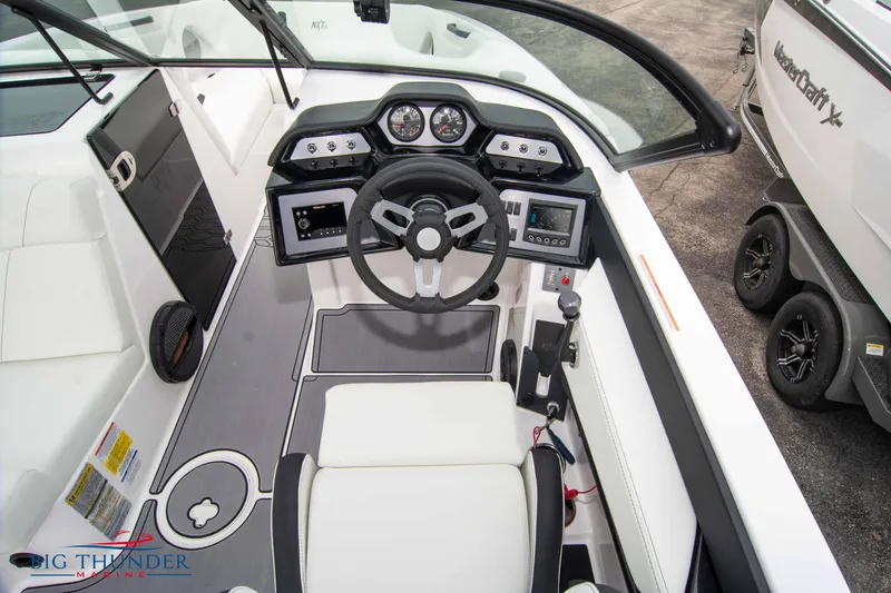 Slide: The Image of 2023 MasterCraft NXT22 boat cockpit with modern dashboard and steering wheel. - 24