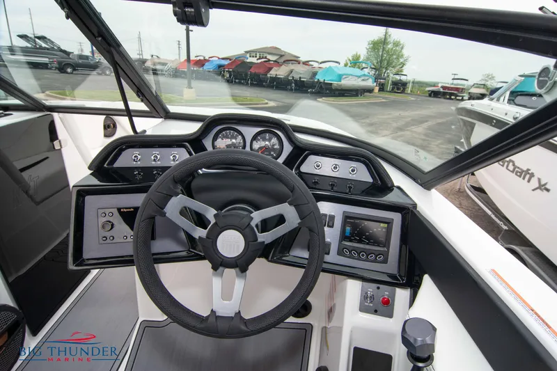Slide: The Image of 2023 MasterCraft NXT22 boat dashboard with steering wheel and control panel. - 26