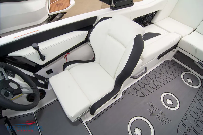Slide: The Image of 2023 MasterCraft NXT22 boat interior with white and black captain's seat and custom flooring. - 36