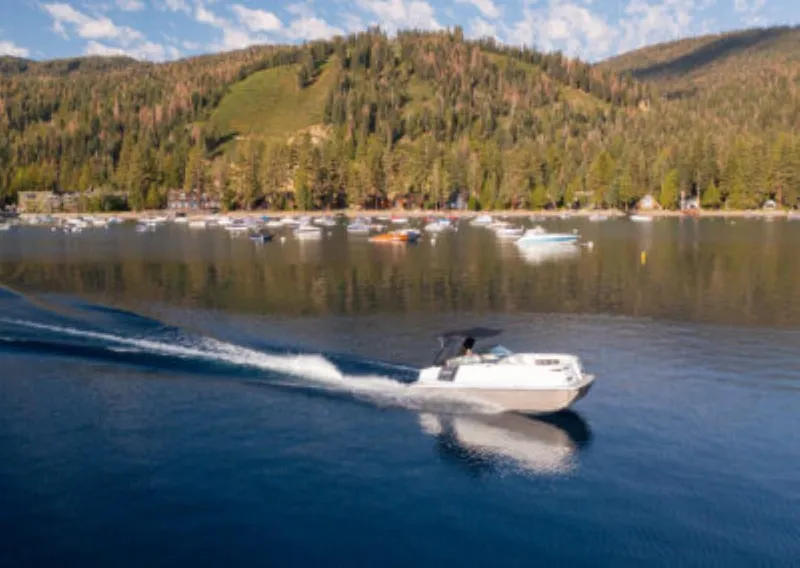 Slide: The Image of Ingenity EL 2025 boat cruising on a serene lake with forested hills in the background. - 5