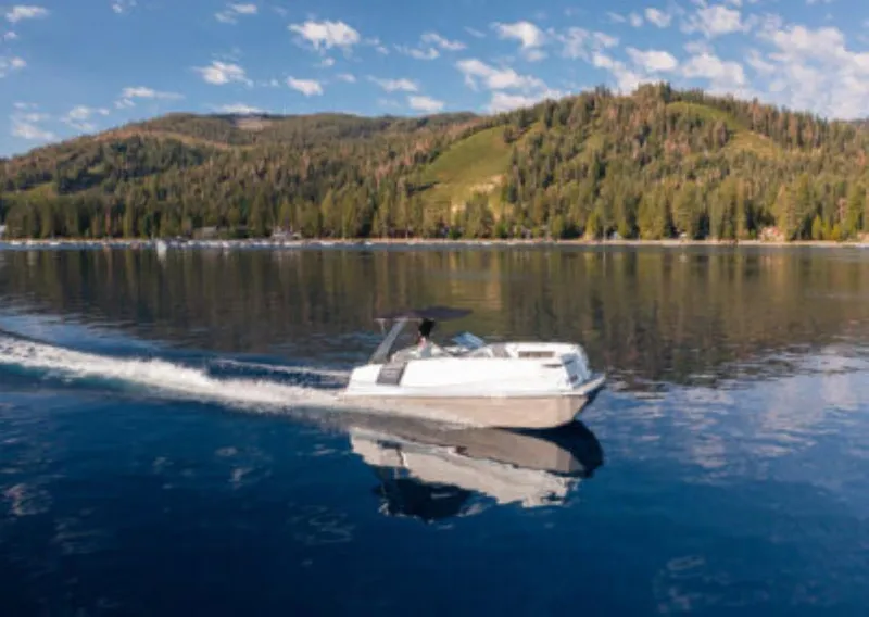 Slide: The Image of Ingenity EL 2025 boat cruising on a serene lake with forested hills in the background. - 6