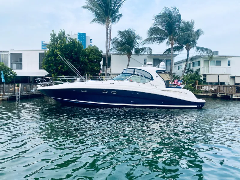 The Image of 2005 Sea Ray 420 Sundancer yacht docked near waterfront homes. - 0