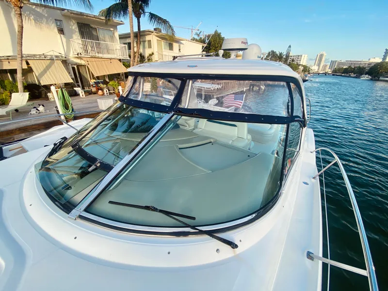 Slide: The Image of 2005 Sea Ray 420 Sundancer yacht docked by waterfront homes. - 23