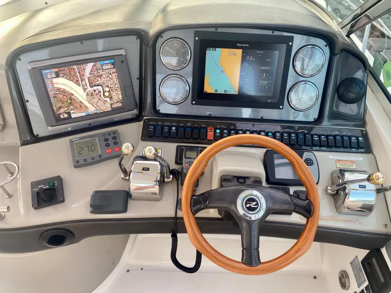 Slide: The Image of 2005 Sea Ray 420 Sundancer helm with navigation screens and controls. - 24