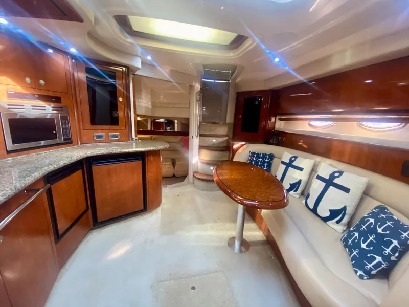Slide: The Image of 2005 Sea Ray 420 Sundancer interior with kitchen, seating area, and nautical decor. - 40