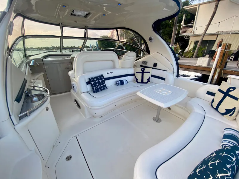 Slide: The Image of 2005 Sea Ray 420 Sundancer boat interior with white seating and nautical-themed pillows. - 5