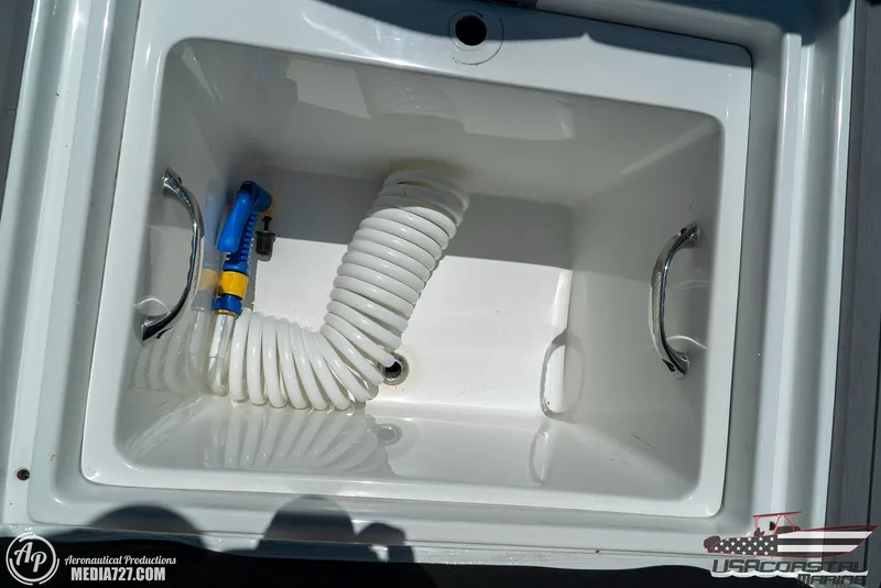 Slide: The Image of 2018 Statement 38 Open boat storage compartment with hose and handles. - 13