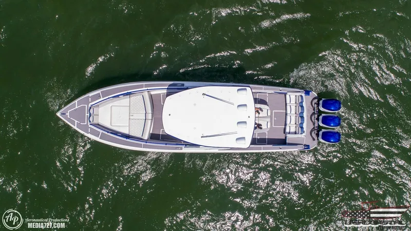 Slide: The Image of Aerial view of 2018 Statement 38 Open boat with triple engines on green water. - 14