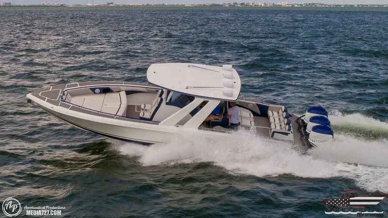 Slide: The Image of 2018 Statement 38 Open boat cruising on the ocean with triple outboard engines. - 38