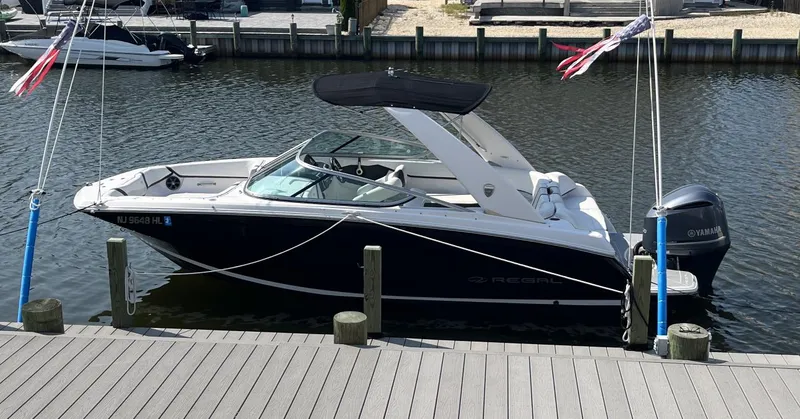 Slide: The Image of 2017 Regal 23 OBX boat docked in a marina, featuring a sleek black hull. - 1