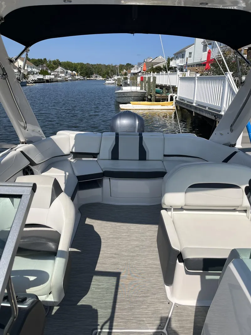 Slide: The Image of 2017 Regal 23 OBX boat interior with seating, docked by waterfront homes. - 8
