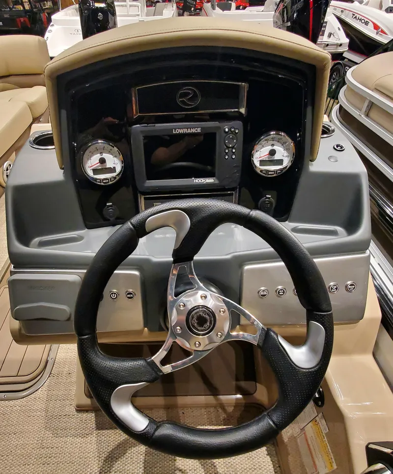 Slide: The Image of 2023 Regency 230 DL3 boat dashboard with steering wheel and navigation system. - 3