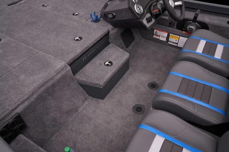 Slide: The Image of 2023 Ranger RT188P boat interior with gray carpet and blue-accented seats. - 27