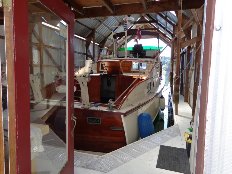 Slide: The Image of 1946 Monk Flybridge Sedan boat docked in a covered marina. - 10